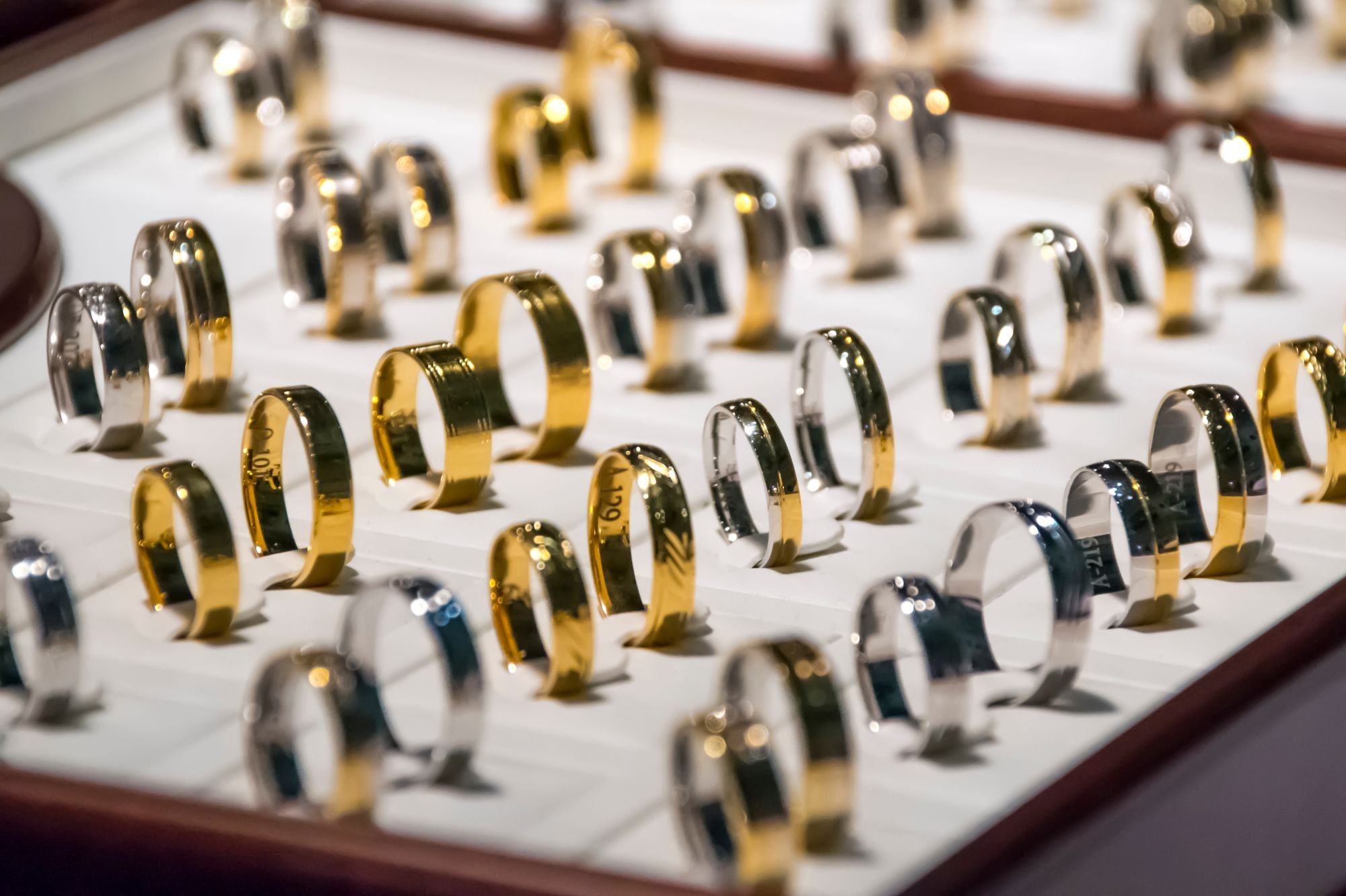 Tablett mit vielen Ringen in Gelbgold und Weißgold, in Reihen gesteckt